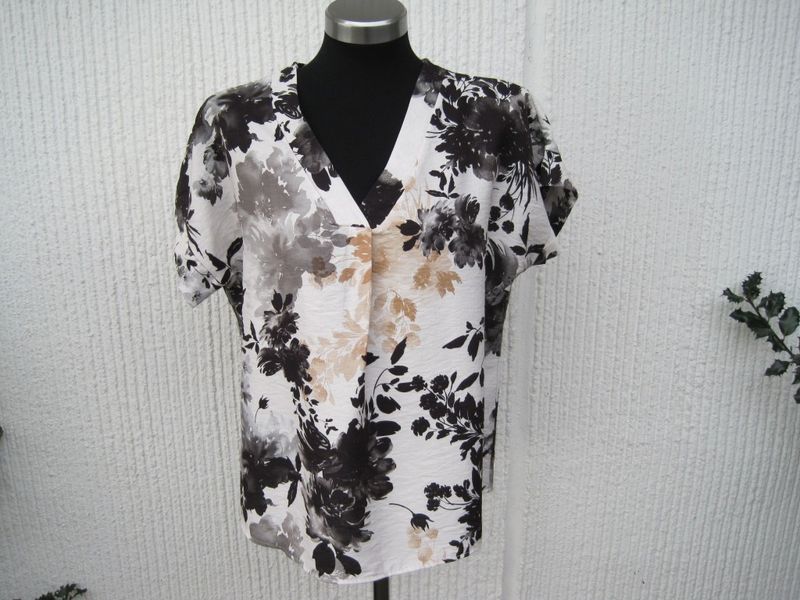 Blommig viskosblus med kort ärm. Natur / svart